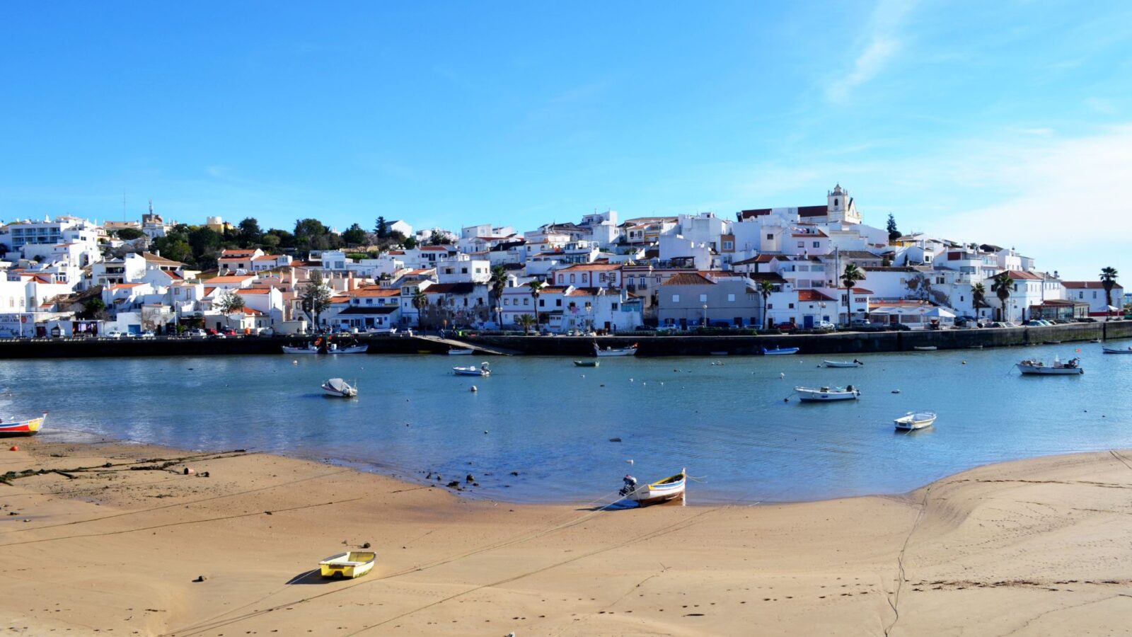 View of Ferragudo, Algarve, with boats and whitewashed houses.