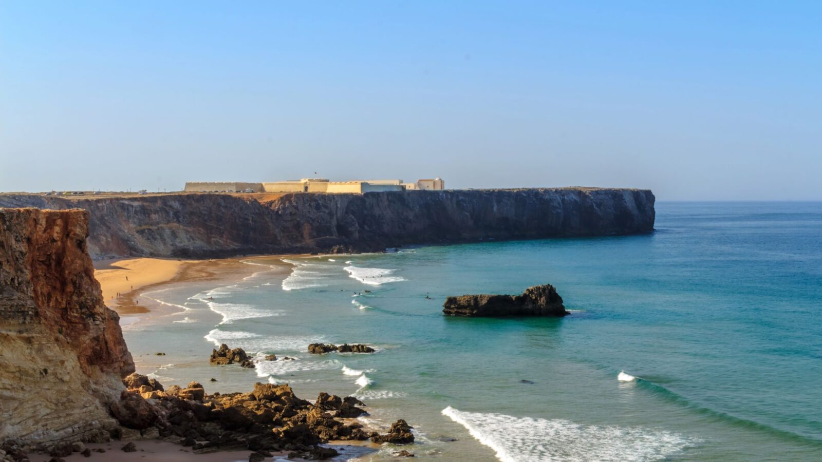 Rugged coastline and golden beach near Sagres.